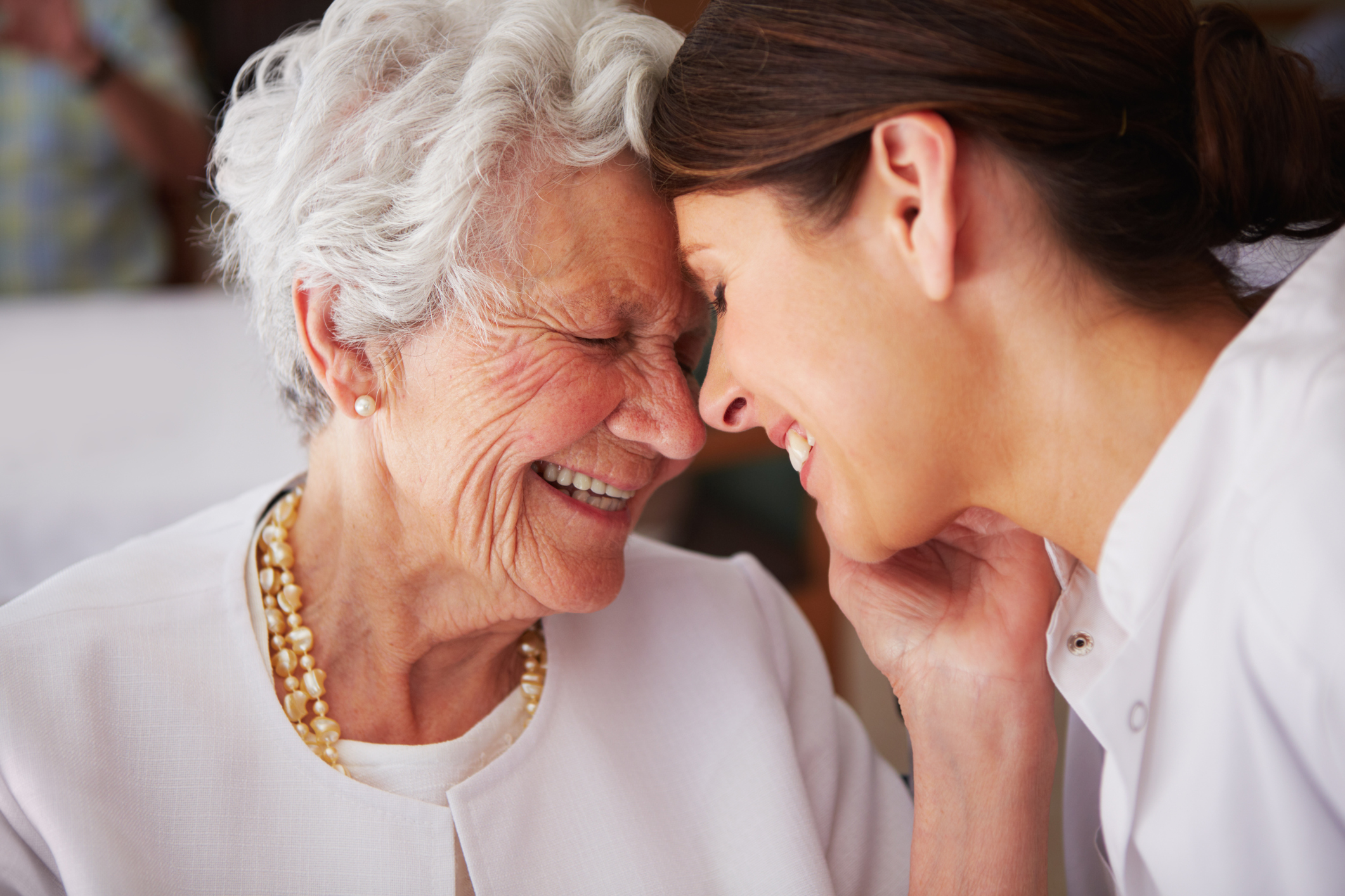 An elderly woman affectionately thanking her nurse