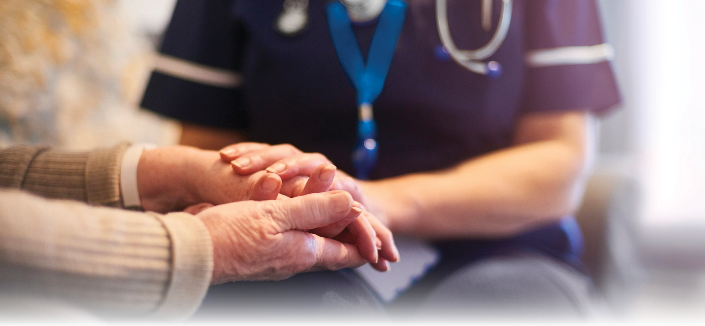 Close-up of a caregiver holding hands senior woman patient