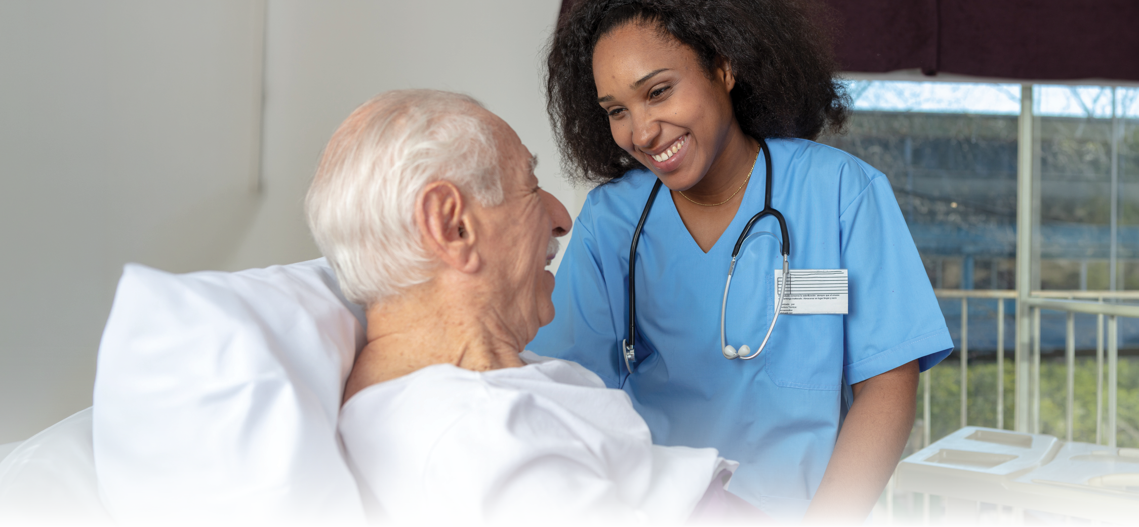 Nurse smiling at the patient lying in bed